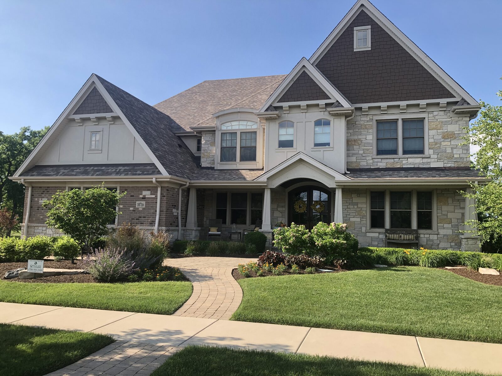 Craftsman shingle style custom home with tapered porch columns, stone and stucco gables built by Spyglass